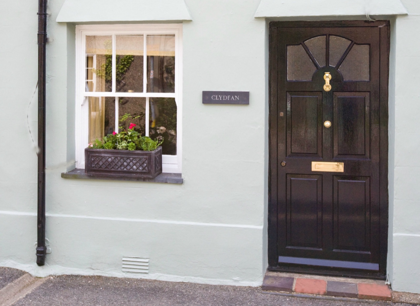 Clydfan Cottage front exterior with stone walls and climbing plants