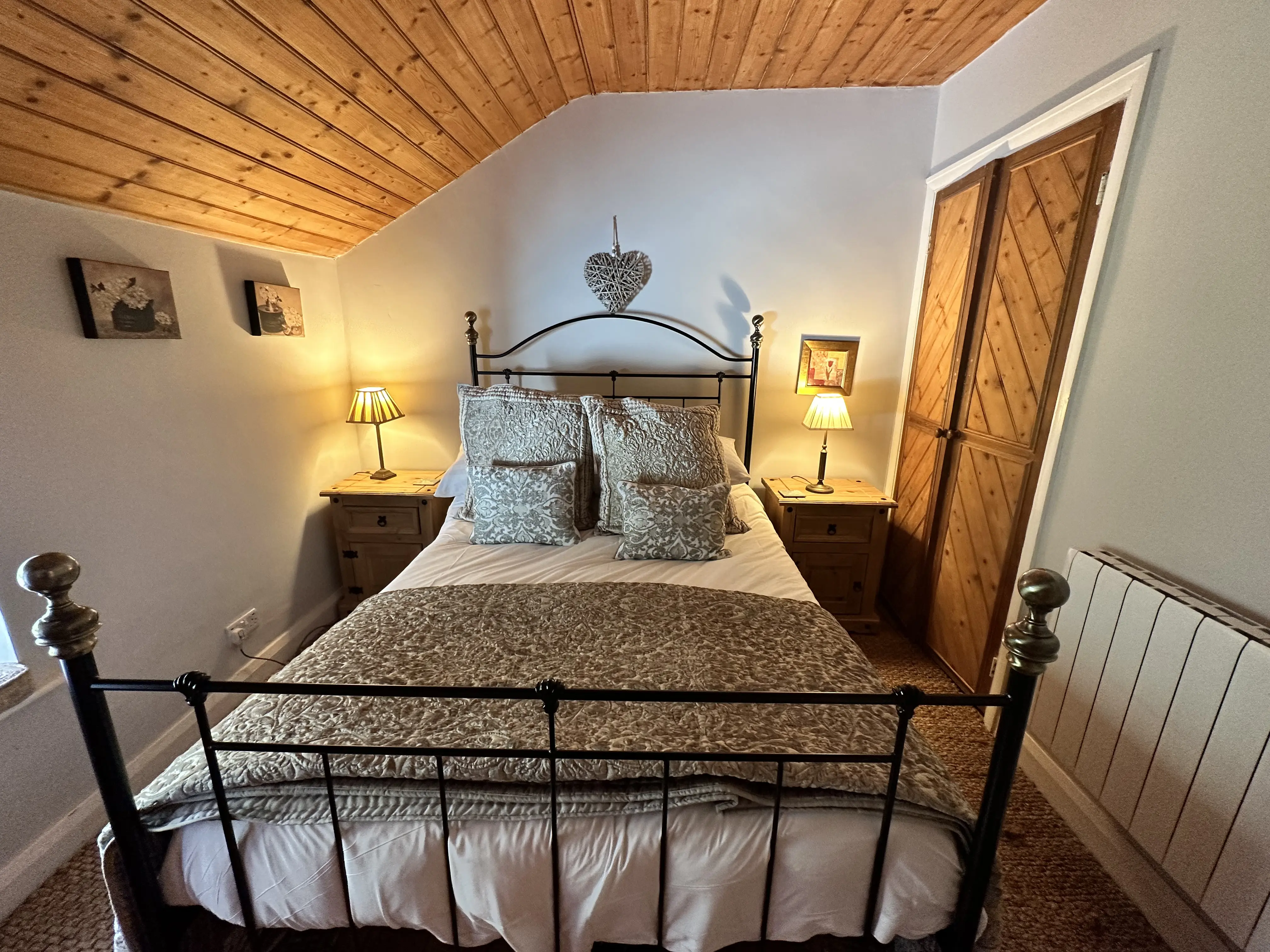 Double bedroom with iron bedstead and bedside lamps